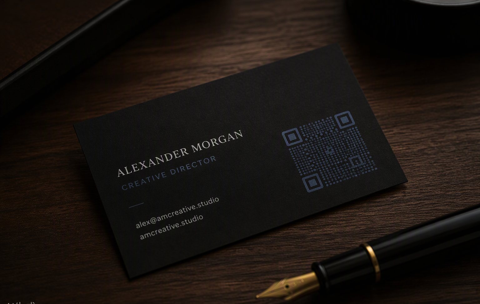 A matte black business card with a refined dot-matrix QR code beside a fountain pen on a dark walnut desk